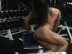 Female bodybuilder working out naked at gym