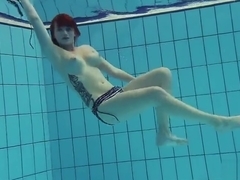 Redheaded Katrin is stripping underwater