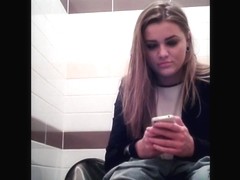 Amateur girl is playing with phone pissing on toilet
