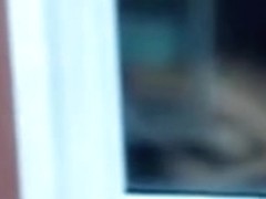 Nude titted female is seen on window voyeur video