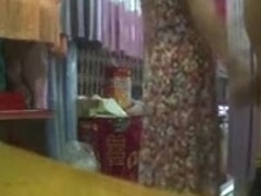 Asian saleswoman helps a guy in the back of the store