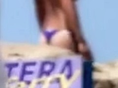Thong babe on the beach has perky tits