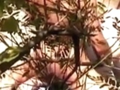 Nudist spy behind a plant