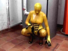 Hot girl in latex glamour yellow catsuit gets to climax