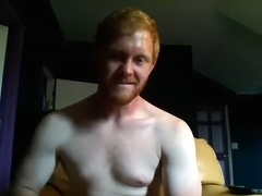 Pretty man is relaxing in a small room and filming himself on computer webcam