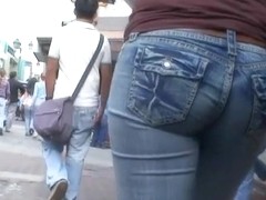 Hot body girl in tight jeans walking the street with a voyeur behind her
