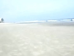Spouse filming his wife on the beach