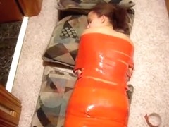 Young brunette laying on the floor wrapped in red tape