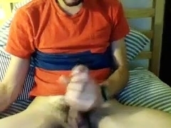 Seductive boy is beating off in a small room and filming himself on computer webcam